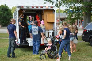 Police Speaking with People behind Vehicle at Event