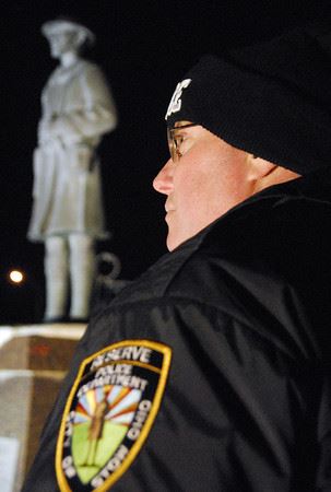 Police Officer Standing in Front of Statue